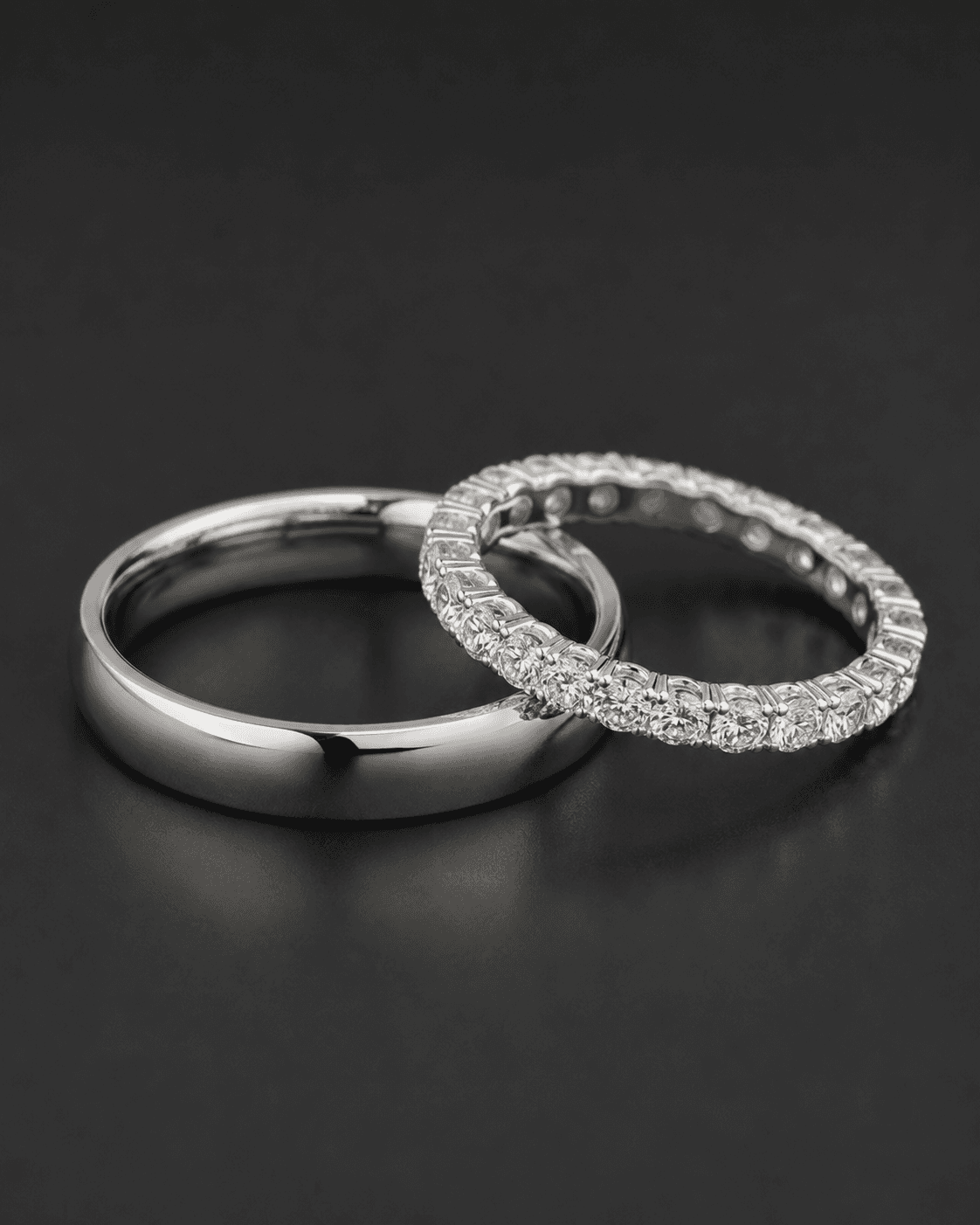 A plain white metal wedding band paired with a diamond eternity band