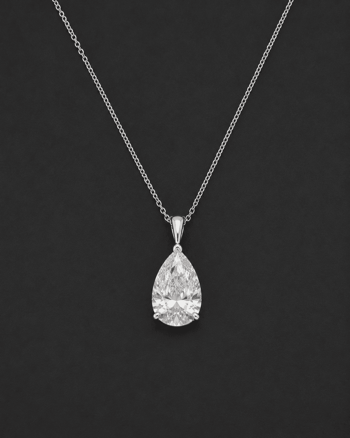 Pear-shaped diamond pendant hanging from a fine white metal chain